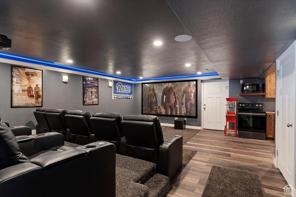 Cinema with dark hardwood / wood-style floors and a textured ceiling