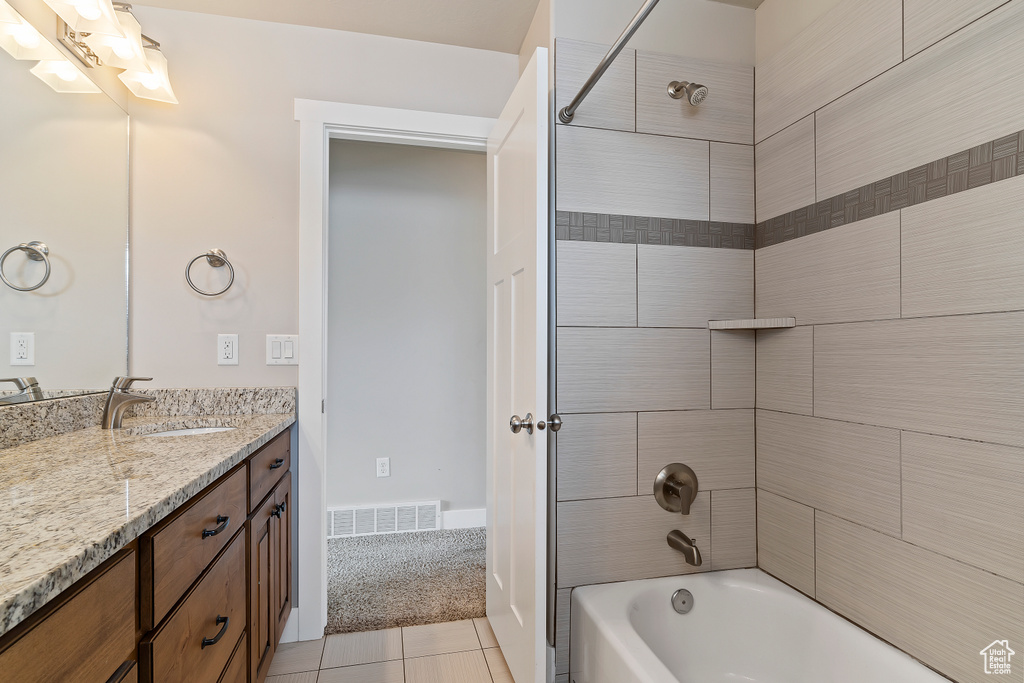 Bathroom featuring tiled shower / bath combo, tile flooring, and oversized vanity