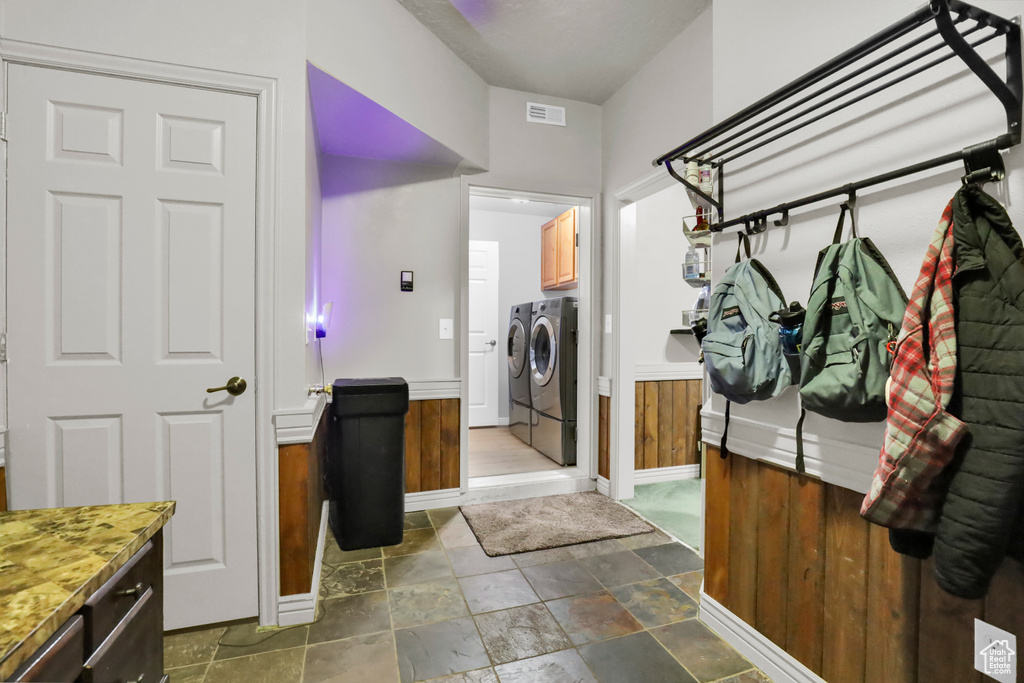 Mudroom with washing machine and dryer and dark tile flooring