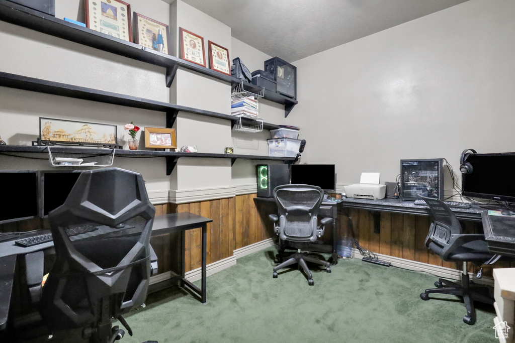 Office area with dark colored carpet and built in desk