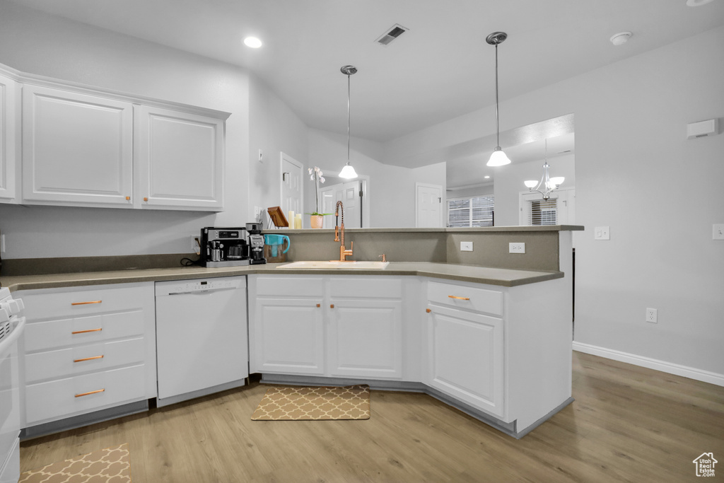 Kitchen featuring pendant lighting, white cabinetry, light hardwood / wood-style flooring, sink, and dishwasher