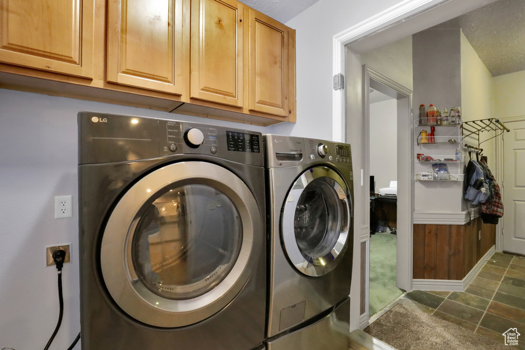 Laundry area featuring independent washer and dryer, cabinets, and carpet flooring
