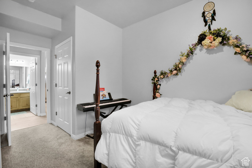Bedroom with light colored carpet and ensuite bathroom