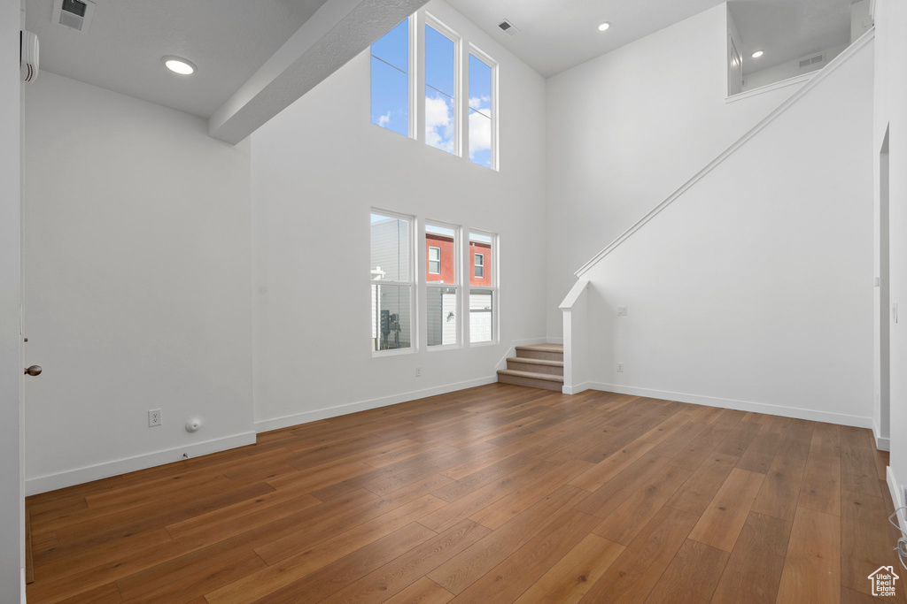 Interior space with dark hardwood / wood-style flooring and a high ceiling
