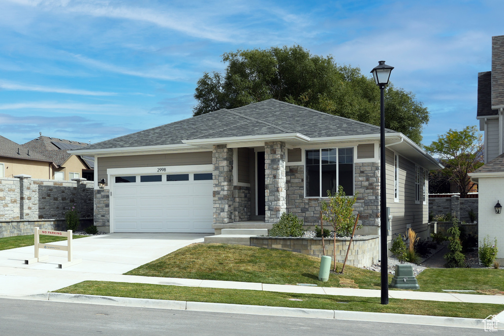 View of front facade with a front yard and a garage