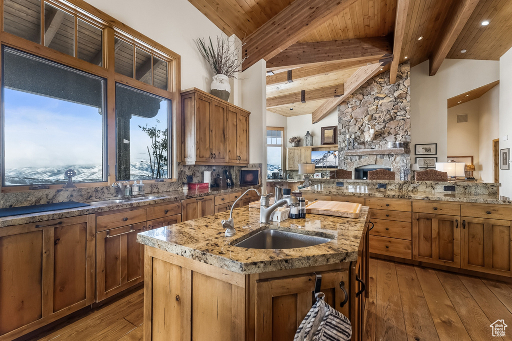 Kitchen featuring sink, wood ceiling, light hardwood / wood-style flooring, and tasteful backsplash