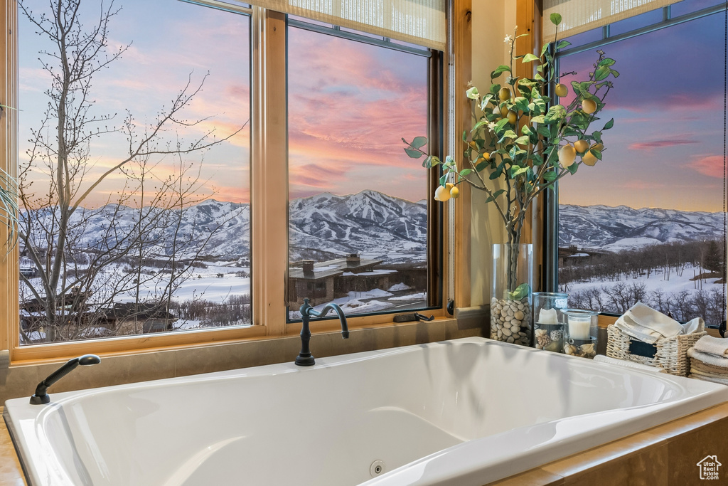 Bathroom with a mountain view and a relaxing tiled bath