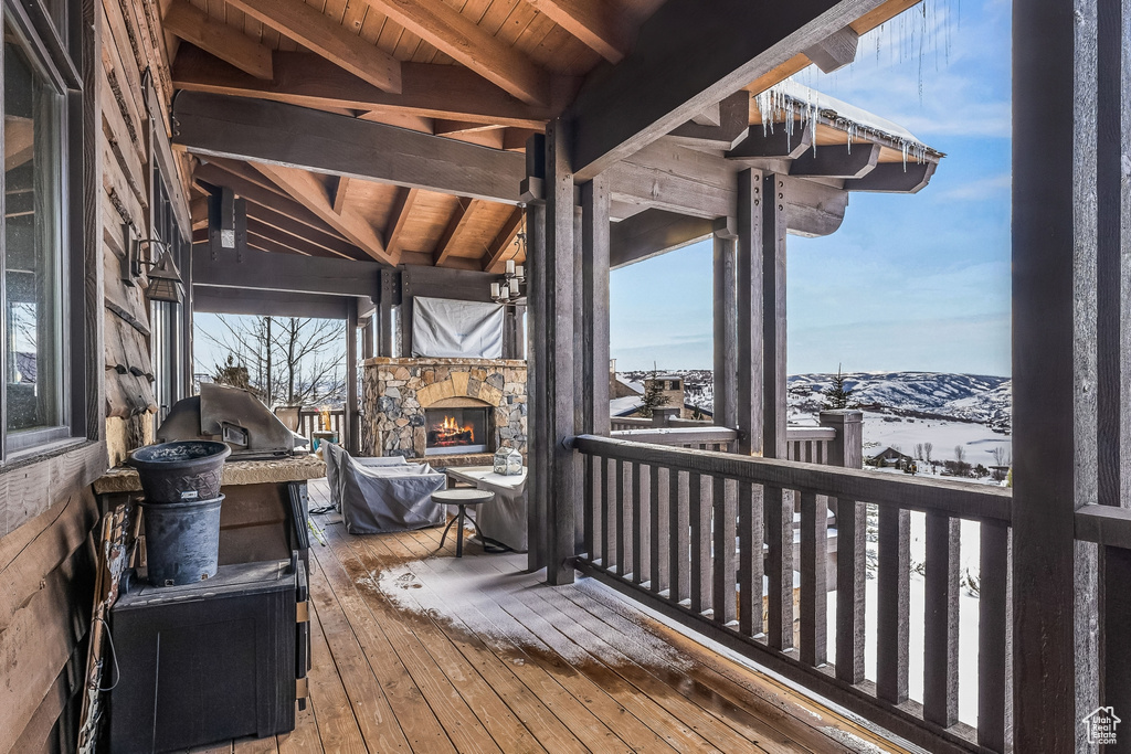Snow covered deck featuring a fireplace