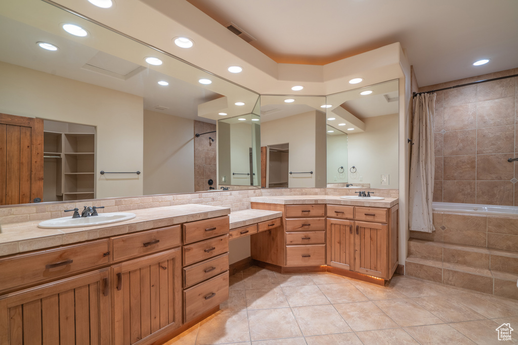 Bathroom with dual bowl vanity, tile flooring, and tasteful backsplash