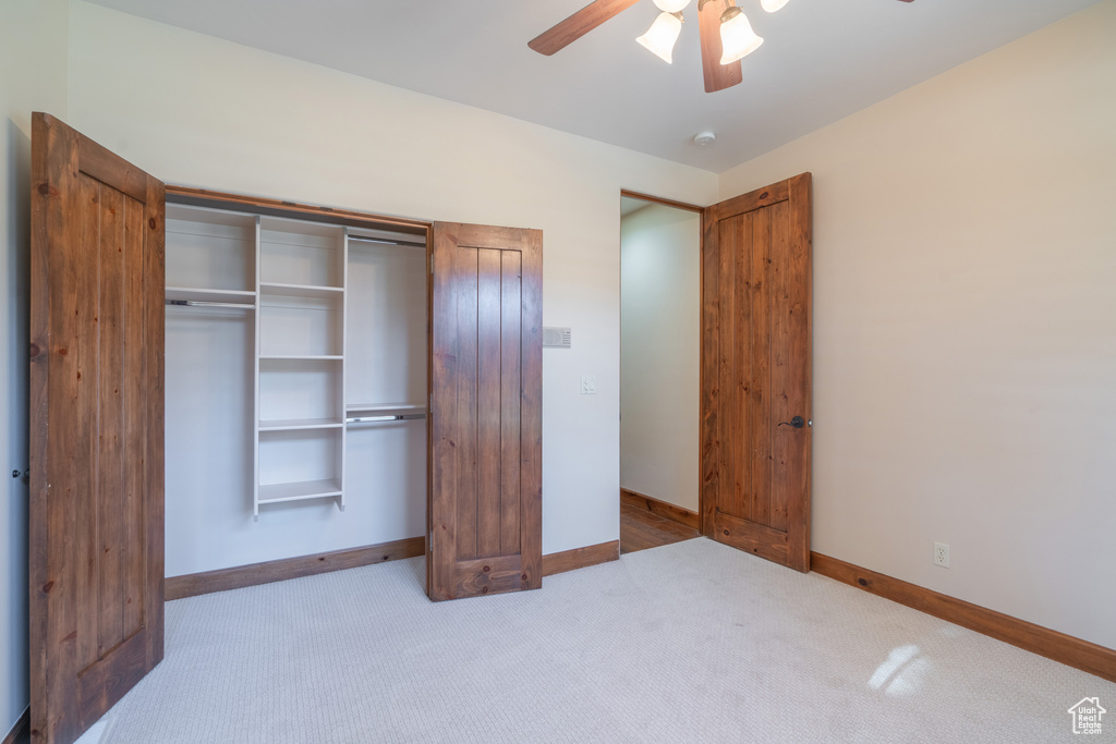 Unfurnished bedroom featuring a closet, ceiling fan, and light carpet