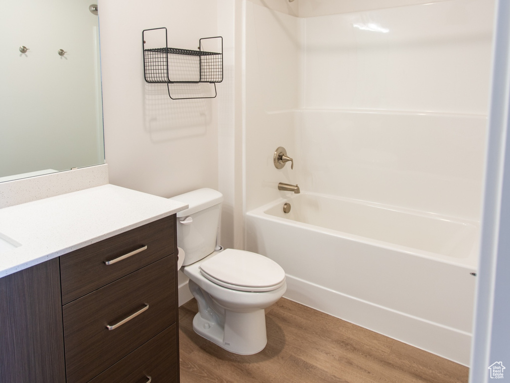 Full bathroom featuring vanity, toilet, hardwood / wood-style floors, and shower / bathing tub combination