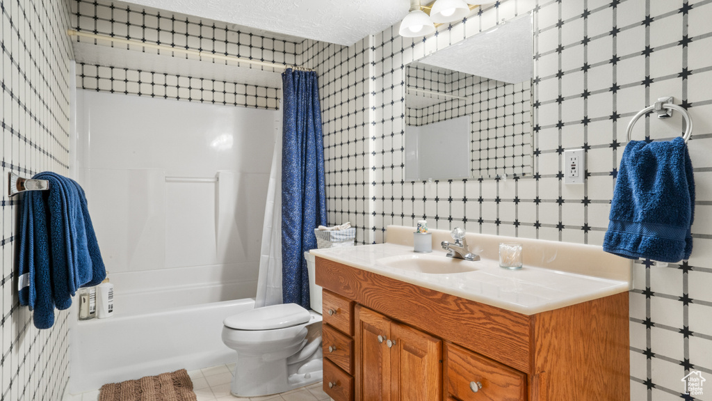 Full bathroom with vanity, shower / bath combo, a textured ceiling, toilet, and tile flooring