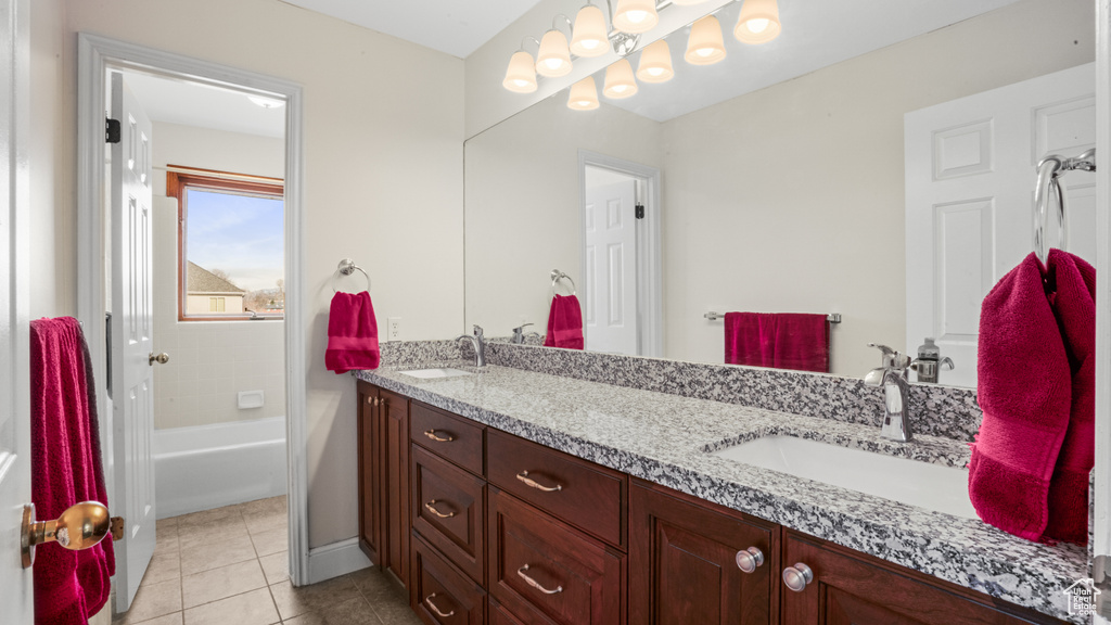 Bathroom featuring dual sinks, tile floors, shower / tub combination, and vanity with extensive cabinet space