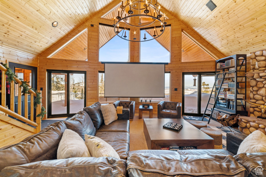 Living room featuring wood ceiling, high vaulted ceiling, a notable chandelier, and log walls