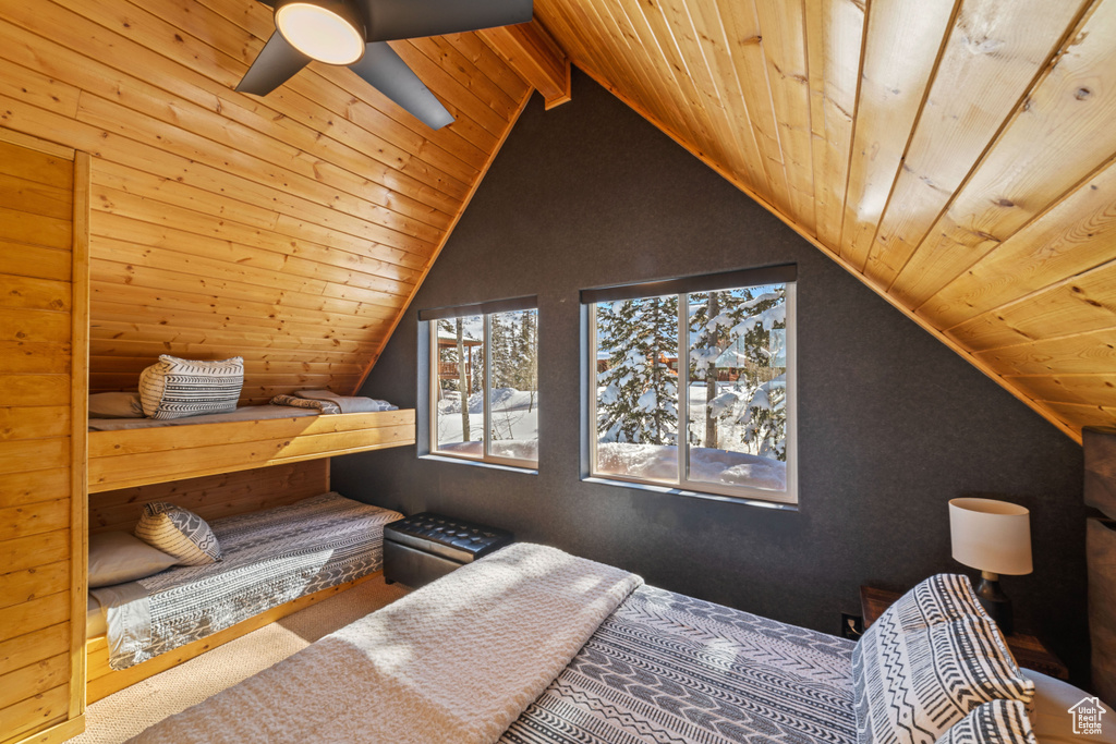 Carpeted bedroom with wood ceiling, vaulted ceiling with beams, and ceiling fan