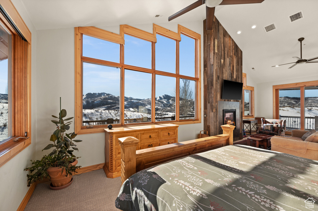Carpeted bedroom featuring multiple windows, a mountain view, and a large fireplace