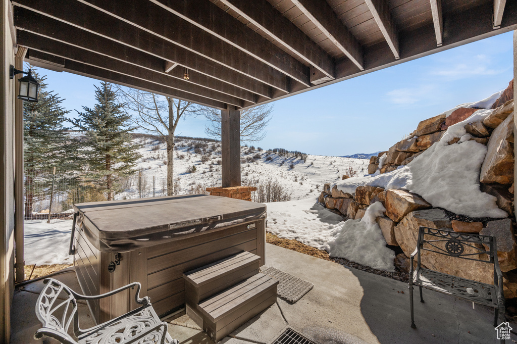 Snow covered patio with a hot tub