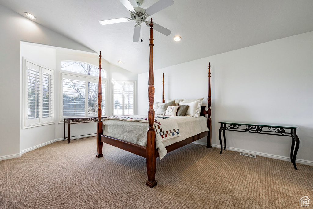 Bedroom with vaulted ceiling, ceiling fan, and carpet