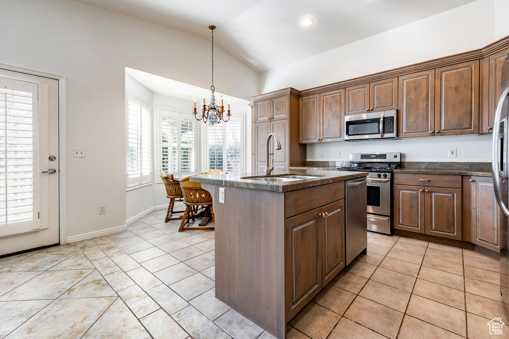 Kitchen featuring a chandelier, appliances with stainless steel finishes, sink, decorative light fixtures, and light tile floors