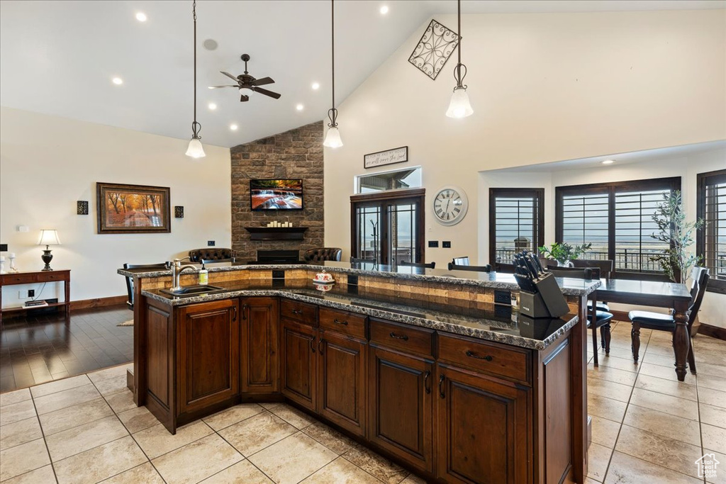 Kitchen with a fireplace, plenty of natural light, ceiling fan, and decorative light fixtures