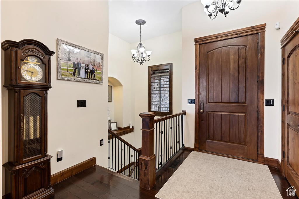 Entrance foyer with a chandelier and dark hardwood / wood-style floors