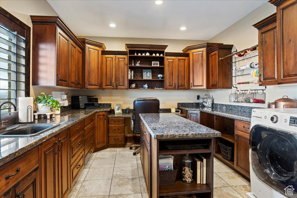 Kitchen featuring light tile flooring, sink, washer / clothes dryer, and dark stone countertops