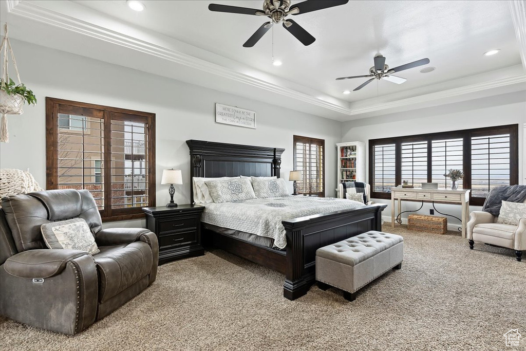 Bedroom with light carpet, ceiling fan, a tray ceiling, and ornamental molding