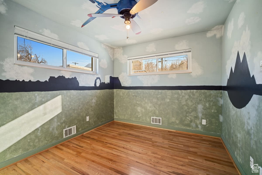 Spare room featuring wood-type flooring and ceiling fan