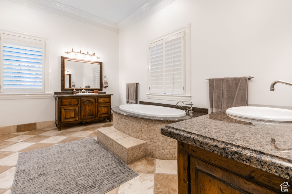 Bathroom featuring vanity, a tub, tile floors, and ornamental molding