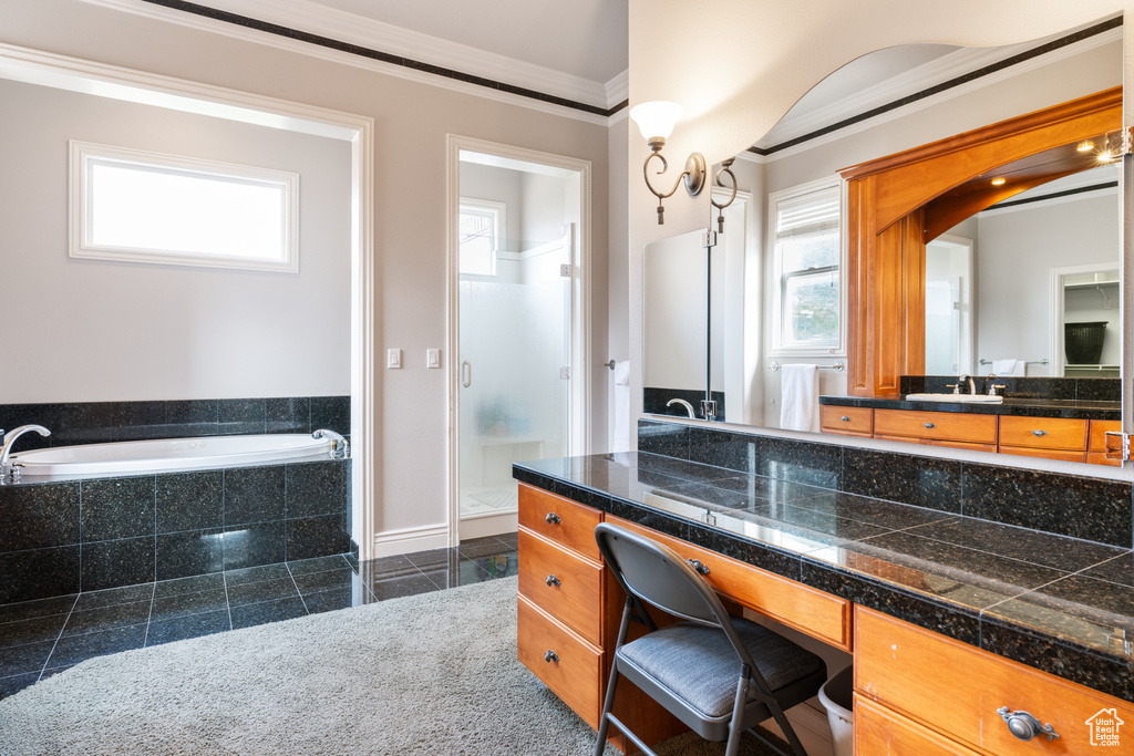 Bathroom featuring vanity, crown molding, tile floors, and tiled tub