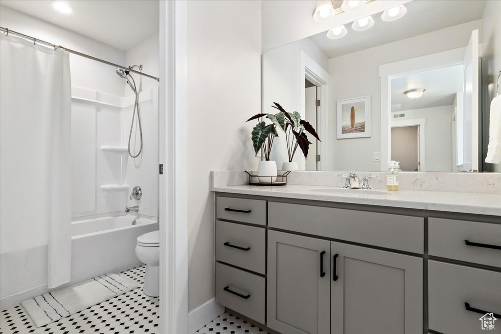 Full bathroom with shower / tub combo, toilet, oversized vanity, and tile flooring