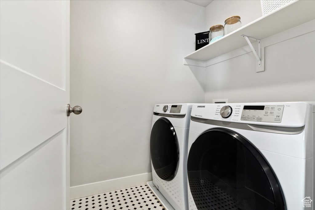 Laundry area featuring washer and clothes dryer and light tile floors