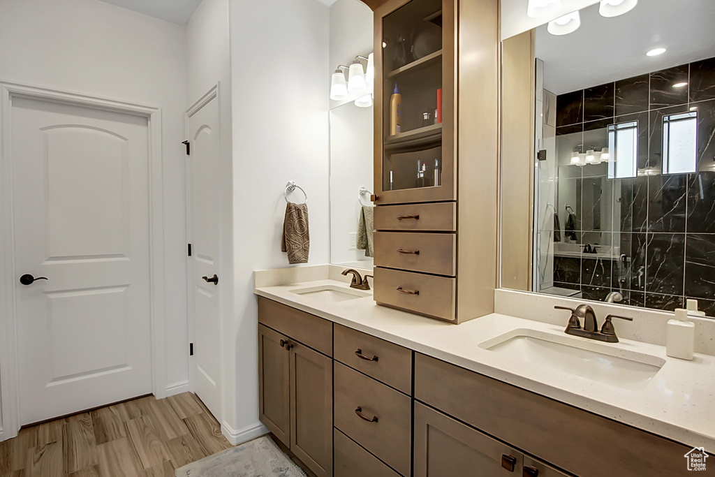 Bathroom featuring wood-type flooring, dual sinks, and oversized vanity