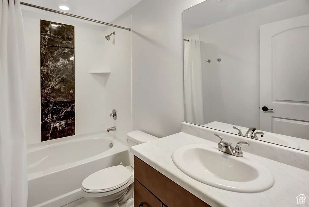 Full bathroom with vanity with extensive cabinet space, shower / bathtub combination with curtain, and toilet