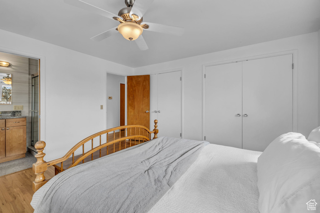 Bedroom with two closets, ceiling fan, connected bathroom, and light wood-type flooring