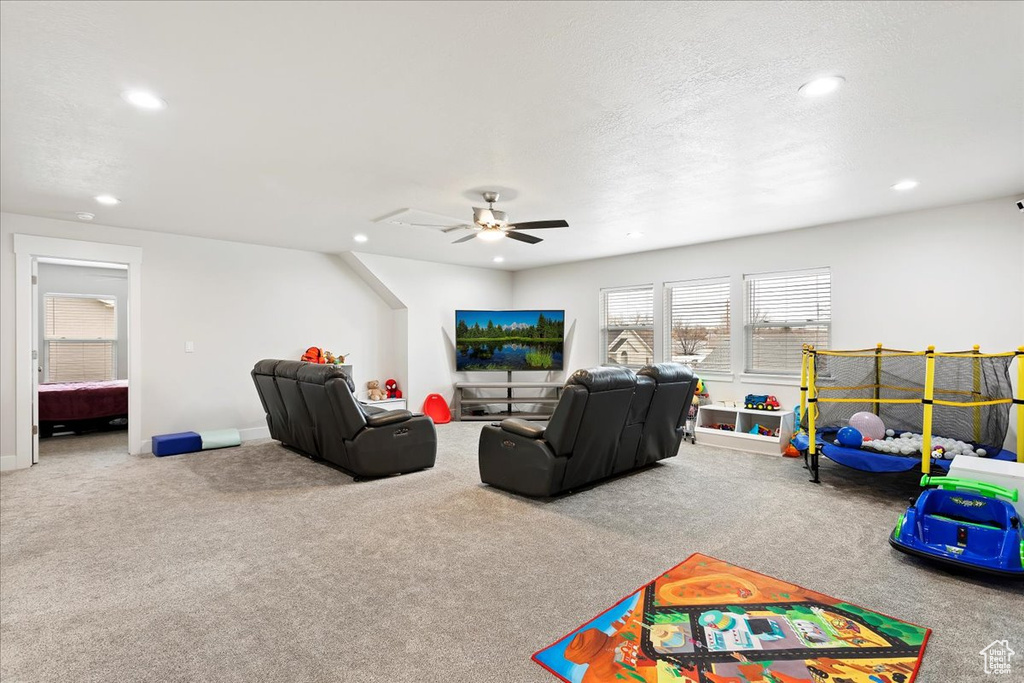 Game room featuring light carpet, a textured ceiling, and ceiling fan