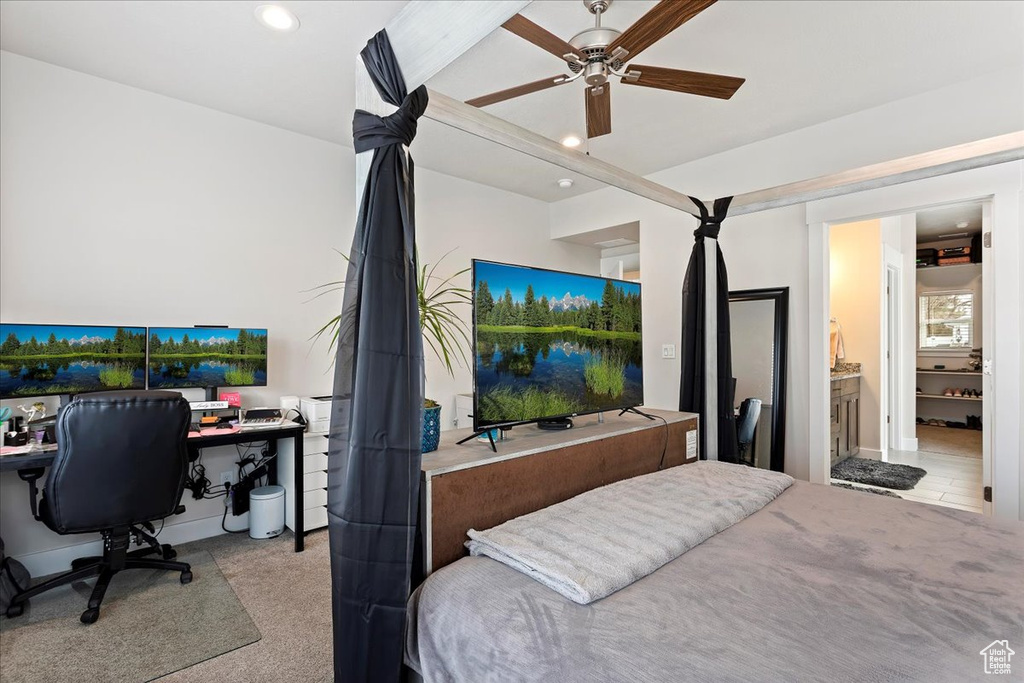 Carpeted bedroom featuring ceiling fan and connected bathroom