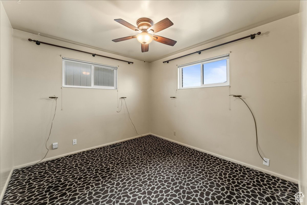Empty room featuring ceiling fan and tile flooring