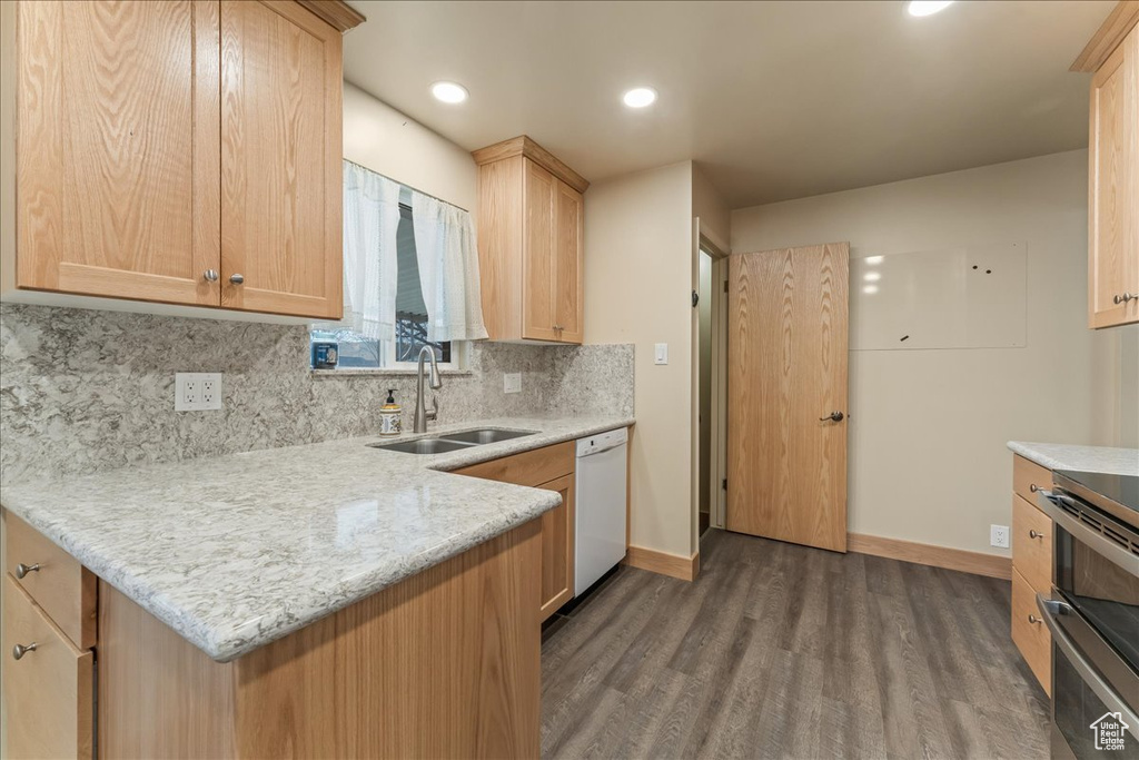 Kitchen with dark hardwood / wood-style floors, white dishwasher, stove, and sink