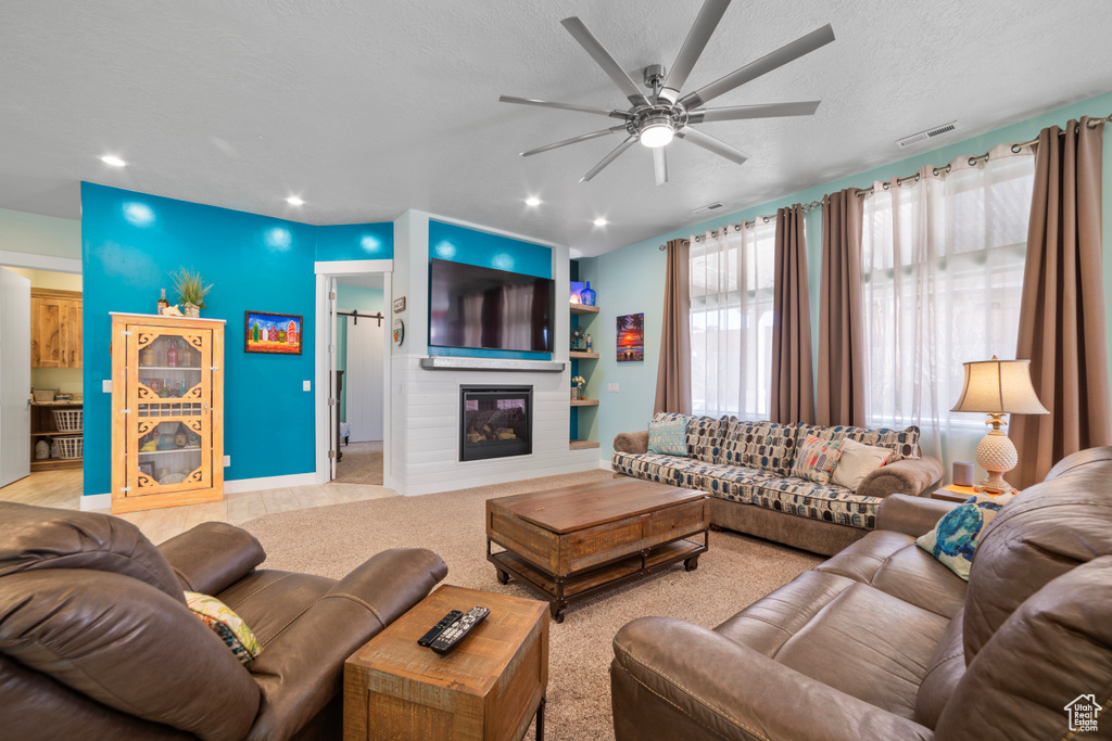 Living room with ceiling fan and a textured ceiling