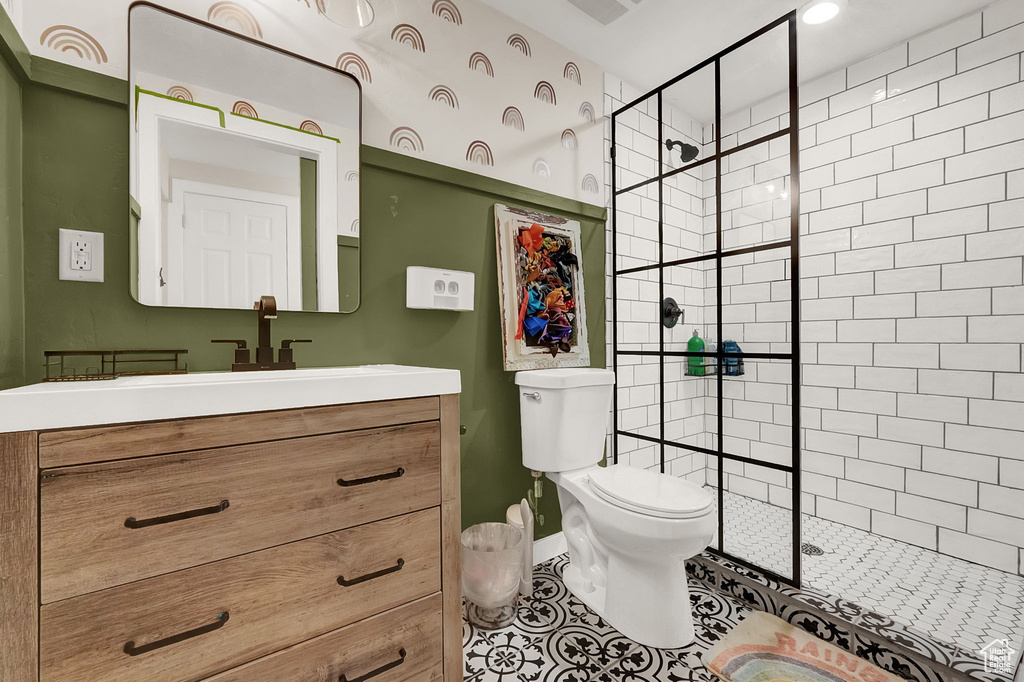 Bathroom featuring vanity, toilet, a shower with door, and tile floors