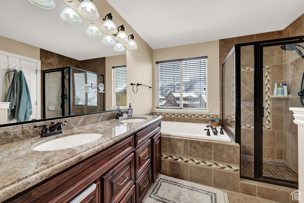 Bathroom with independent shower and bath, double sink vanity, and tile flooring
