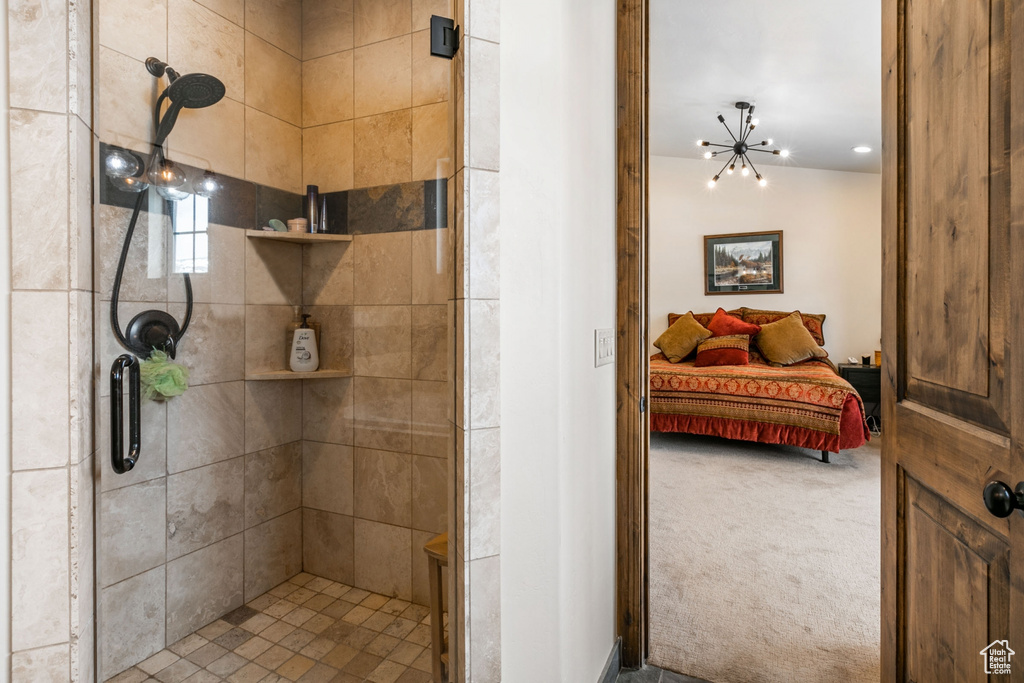 Bathroom with a notable chandelier and an enclosed shower
