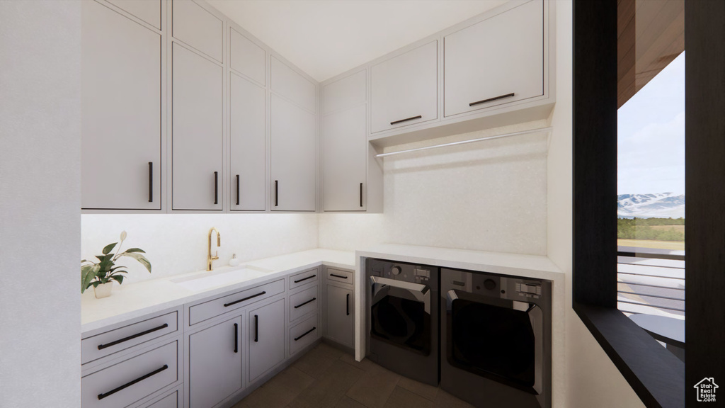 Laundry room with dark tile floors, separate washer and dryer, cabinets, and sink