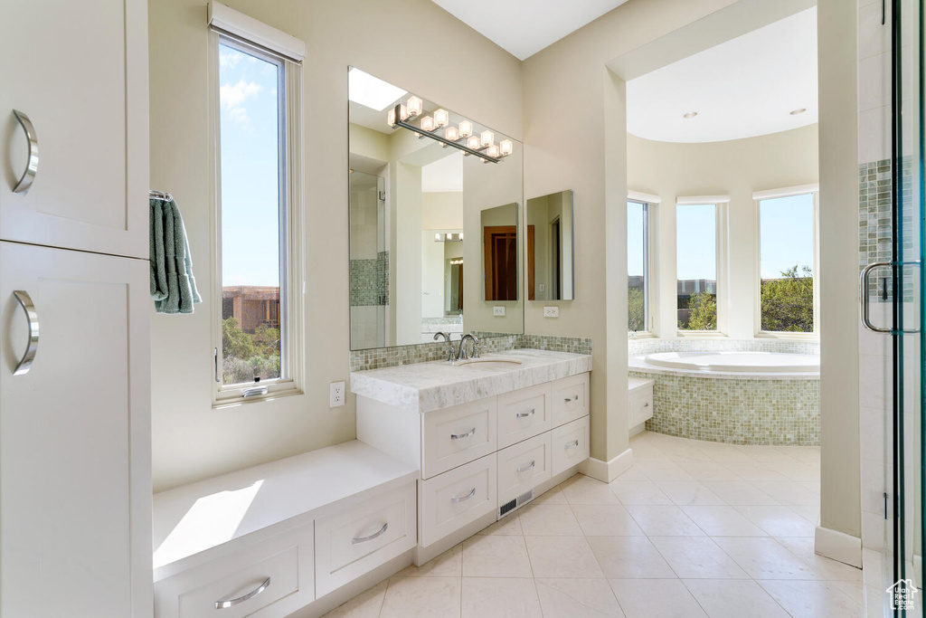 Bathroom featuring plenty of natural light, tile floors, vanity, and independent shower and bath