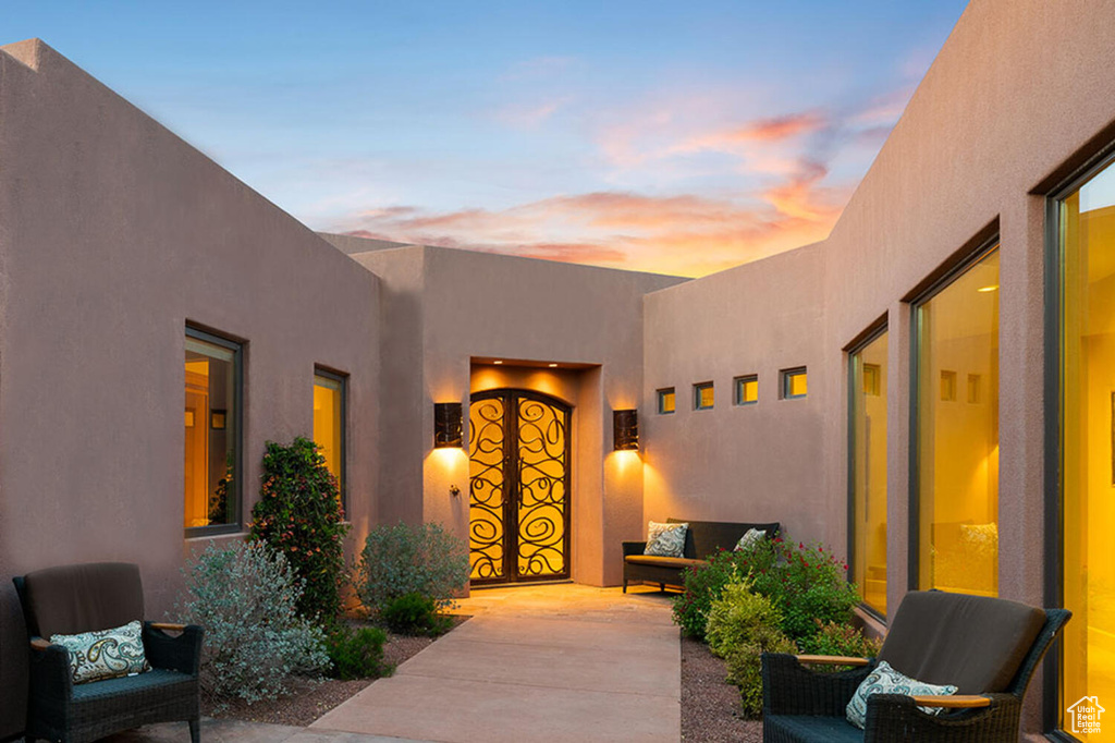 Exterior entry at dusk with a patio and an outdoor hangout area