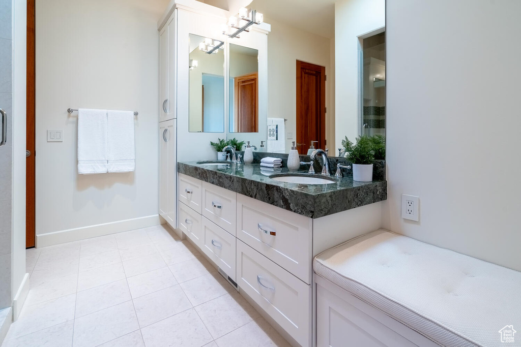 Bathroom featuring a chandelier, tile floors, and dual vanity