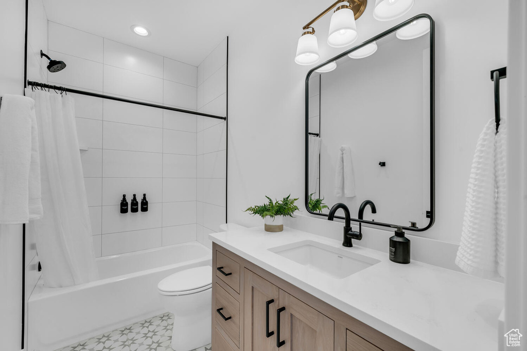Full bathroom featuring vanity, shower / bath combo, tile flooring, and toilet