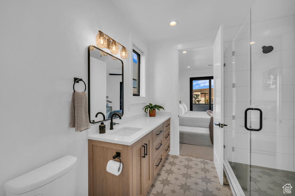 Bathroom featuring vanity, tile flooring, walk in shower, and toilet