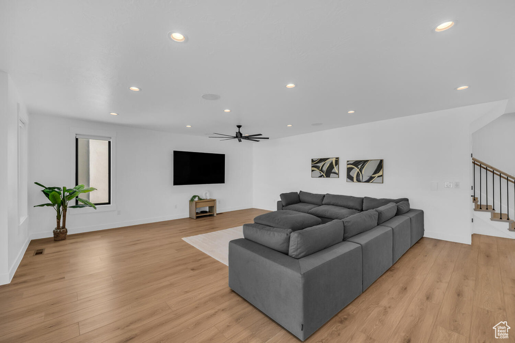 Living room with light wood-type flooring and ceiling fan